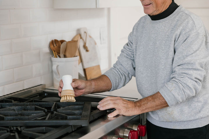 Man cleaning stove with Dish Stick.