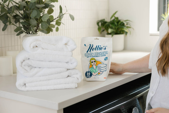 Nellie's Oxygen Brightener and a stack of white towels.