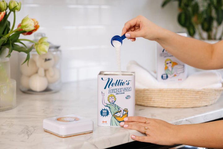 A person doing laundry with Nellie's Laundry Soda.