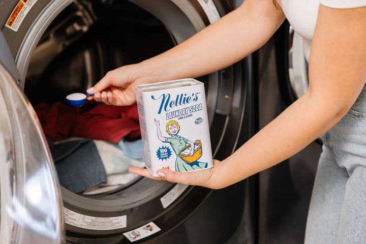 Person placing Laundry Soda in the washing machine.