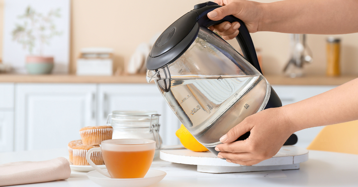 Someone pouring hot water out of a tea kettle.