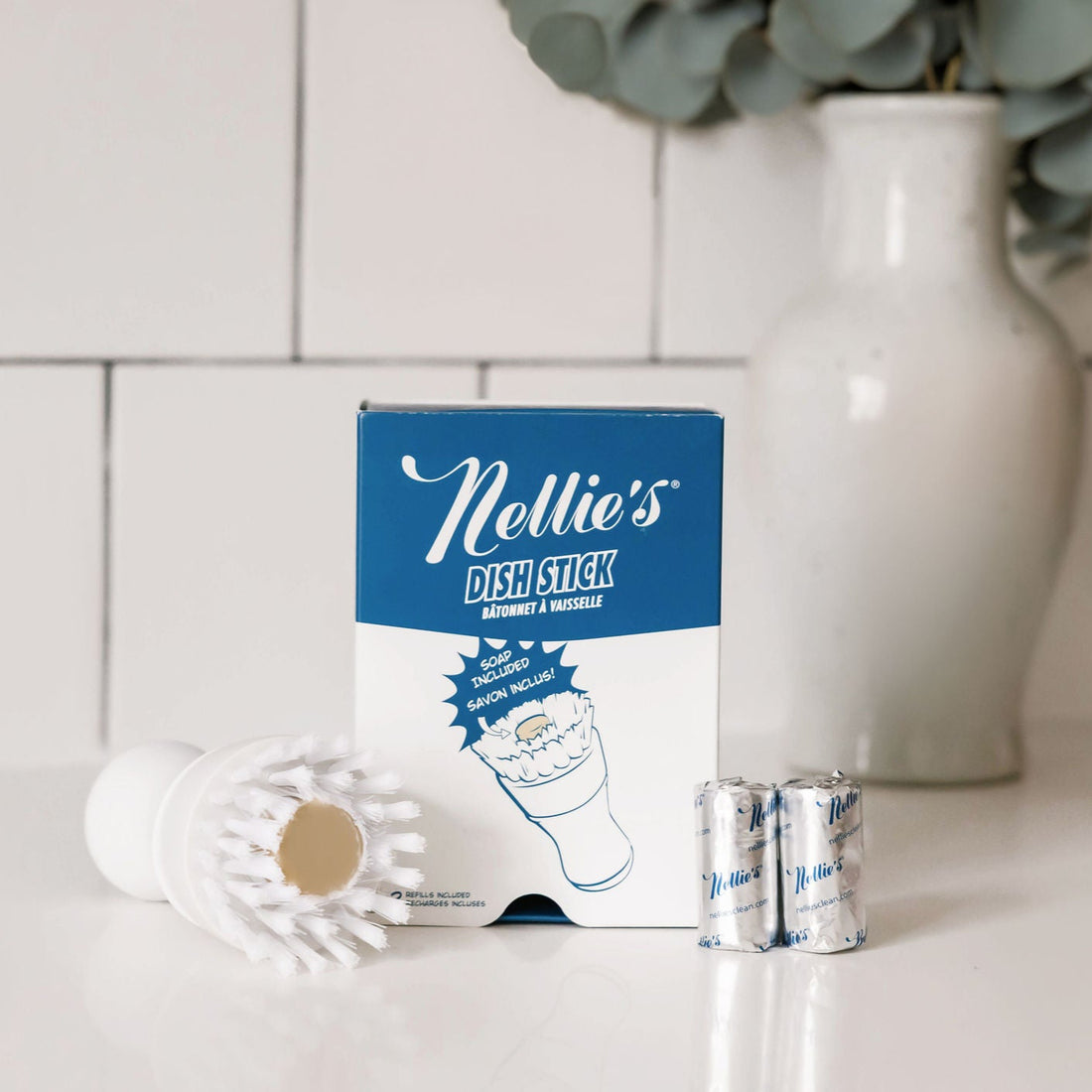 Nellie's Dish Stick packaging with dish stick and canisters on a kitchen counter.
