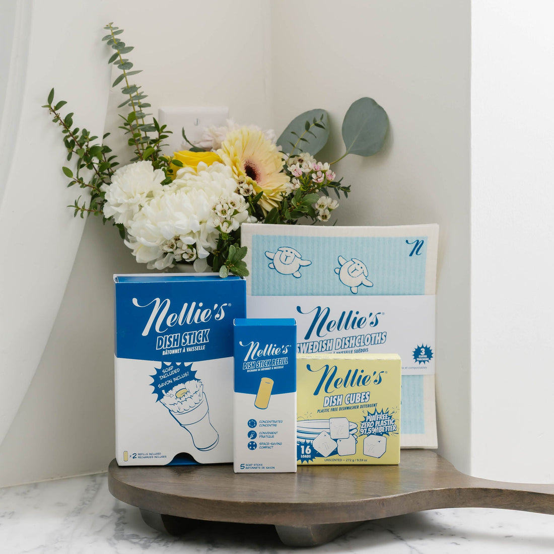 Nellie's Dishwashing bundle on a wooden surface with flowers in the background
