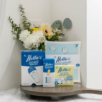 Nellie's Dishwashing bundle on a wooden surface with flowers in the background