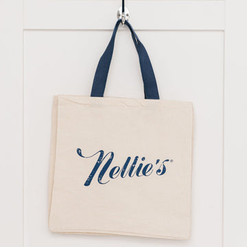 Nellie's cream coloured tote with Nellie's logo hanging on wall hook