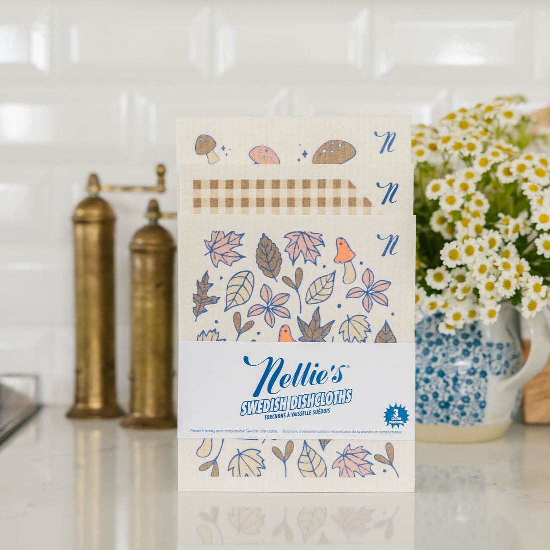 Packaging of Nellie's Swedish Dishcloths on a kitchen counter with decorative elements.