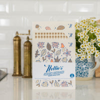 Packaging of Nellie's Swedish Dishcloths on a kitchen counter with decorative elements.